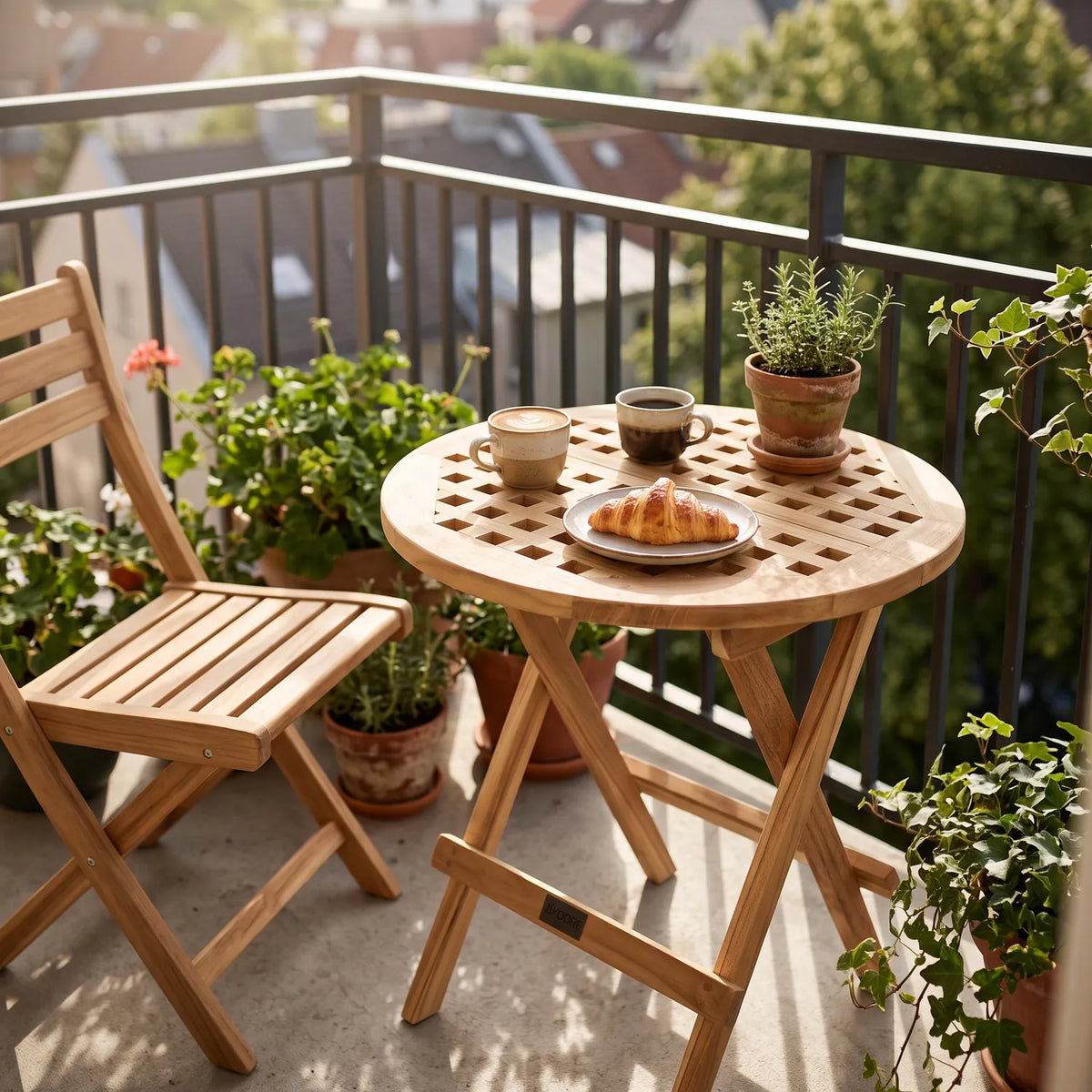 Round Folding Slatted Teak Table Ø50 cm on a balcony with coffee and a croissant